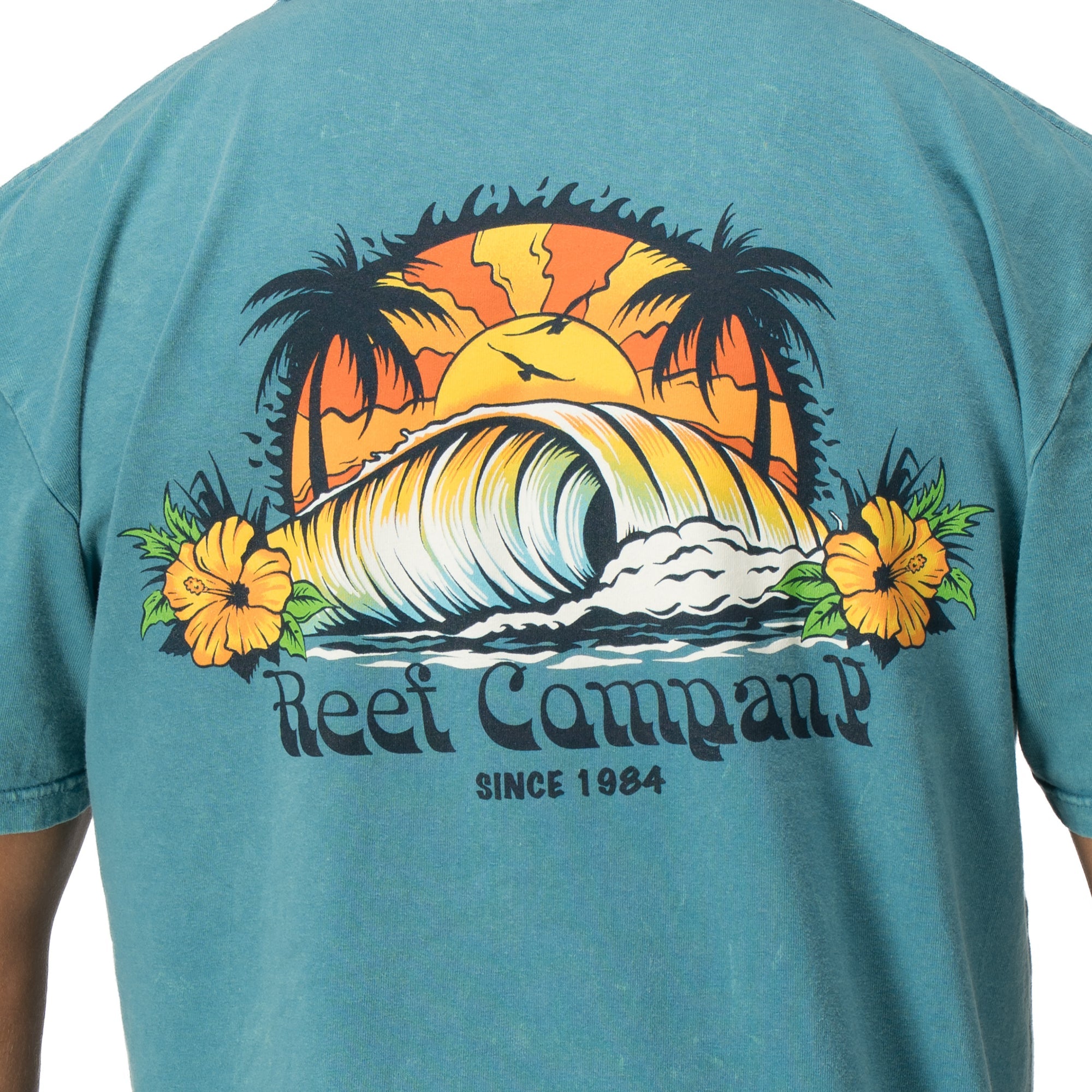 Back view of Kyle Short Sleeve Tee in sun-faded blue with vintage surf wave and palm tree graphic for beach comfort.
