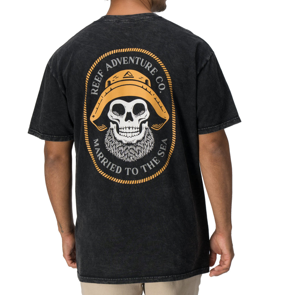 Back view of a man wearing a black Salty Short Sleeve Tee featuring vintage skull and hat artwork, coastal style apparel.