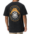 Back view of a man wearing a black Salty Short Sleeve Tee featuring vintage skull and hat artwork, coastal style apparel.