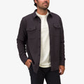 Man wearing dark button-up Raymond Ls Shirt over white tee, with hands in pockets, front view, beach-inspired comfort apparel.