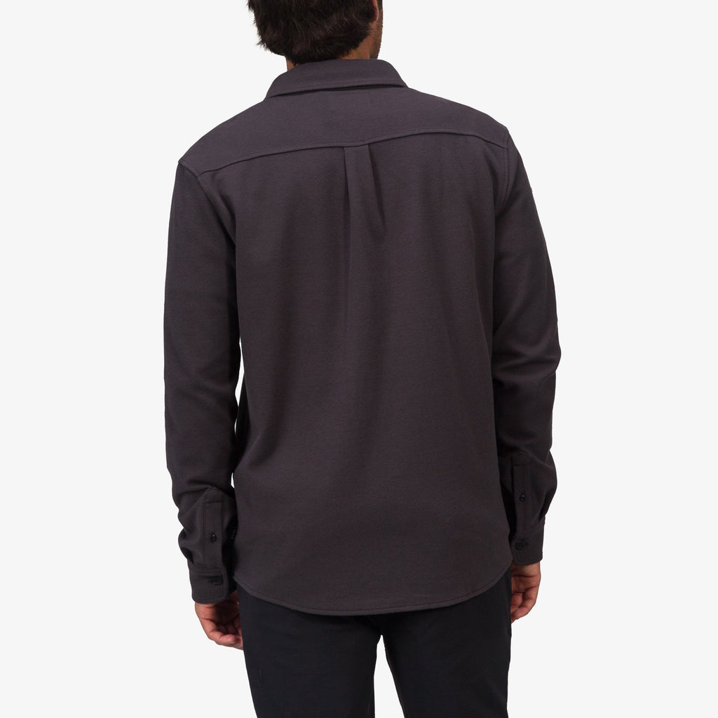 Back view of a man wearing the Raymond Ls Shirt in dark gray, showcasing its casual, surf-inspired comfortable apparel style.