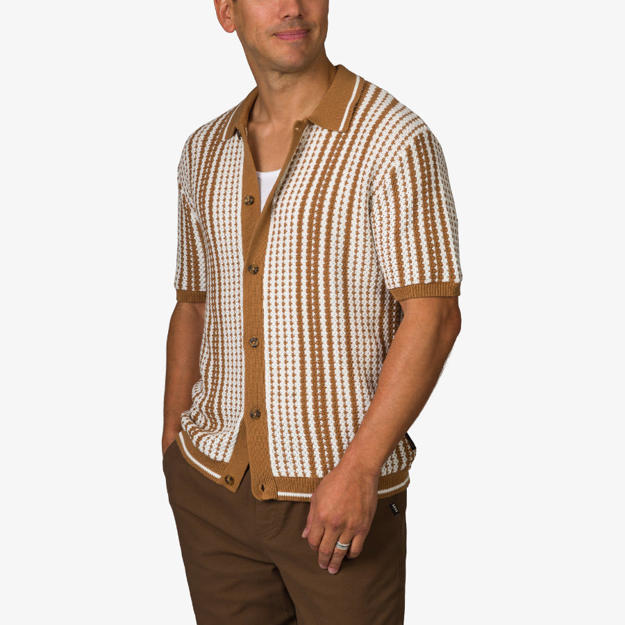 Adult male wearing a Cabana Knit Sweater with brown and white stripes, styled for a casual beach-inspired look
