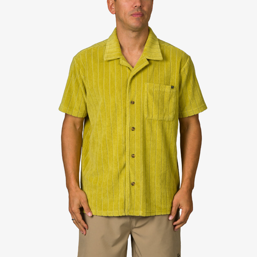 Man wearing a mustard yellow Myran Camp Shirt with short sleeves and vertical stripes, front pocket visible, standing straight.