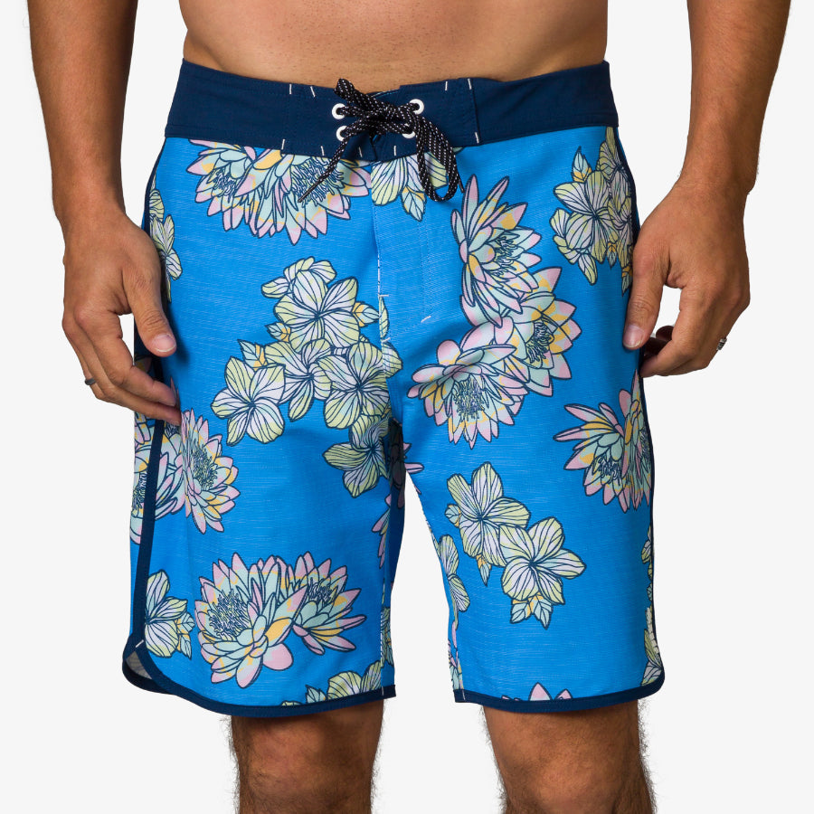 Front-facing Tanner Boardshort in blue with floral pattern, designed for comfort and beach lifestyle.