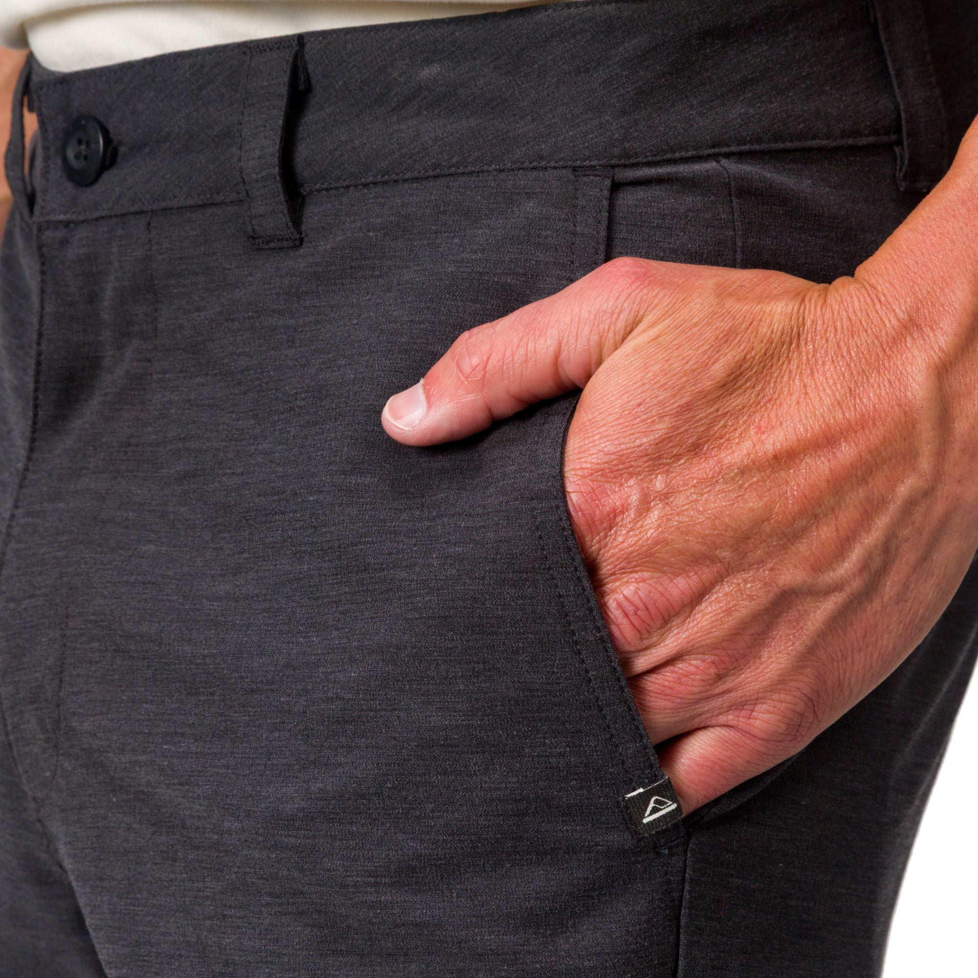 Close-up of a man's hand in the front pocket of black Destro Hybrid Short showing fabric texture and fit.