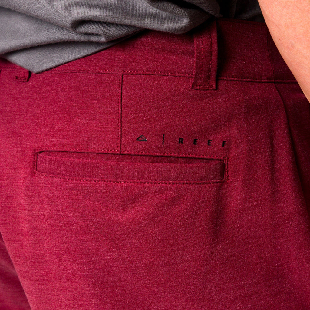 Close-up of the back pocket and logo on men's Destro Hybrid Short in burgundy, surf-inspired comfort apparel.