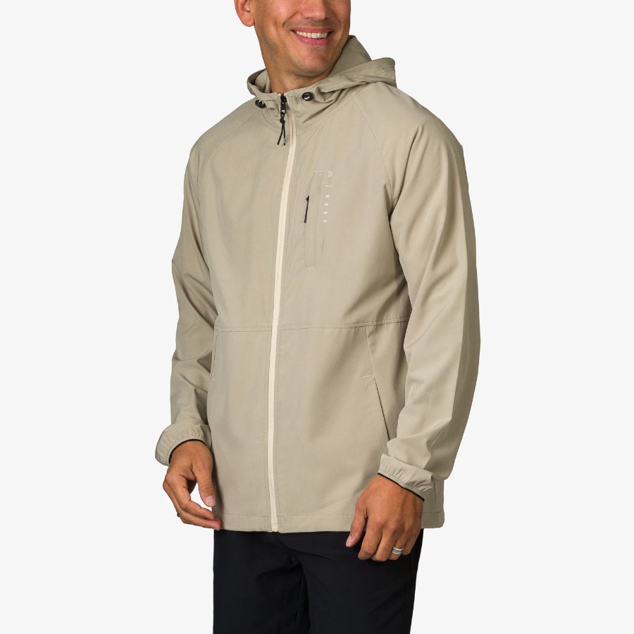 Man wearing a beige Garvey Jacket facing forward with hands relaxed, designed for comfort and active beach lifestyles.