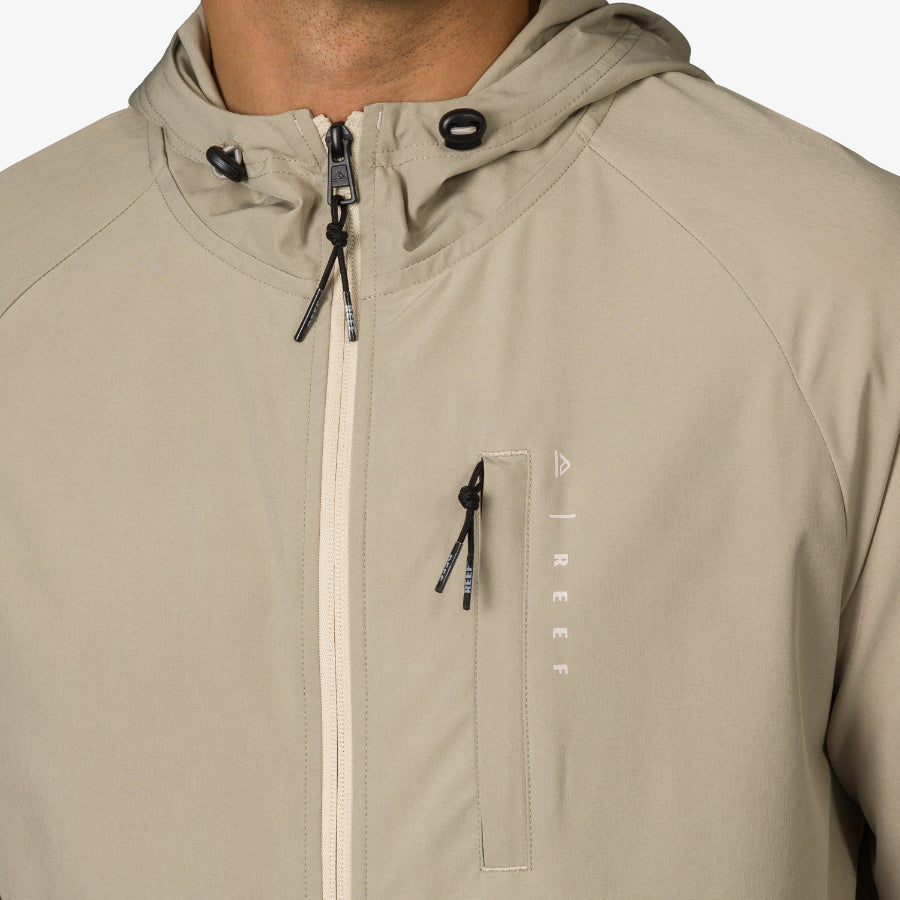 Close-up of the upper chest and hood area of the beige Garvey Jacket for men, featuring zipper and drawstring details.