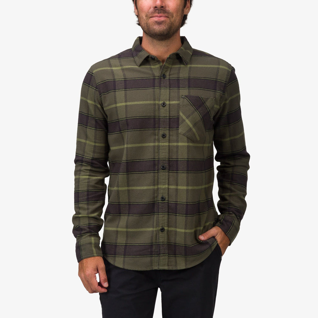 Front view of a man wearing the Anders Long Sleeve Woven Shirt in olive plaid, pocket visible, styled casually with black pants