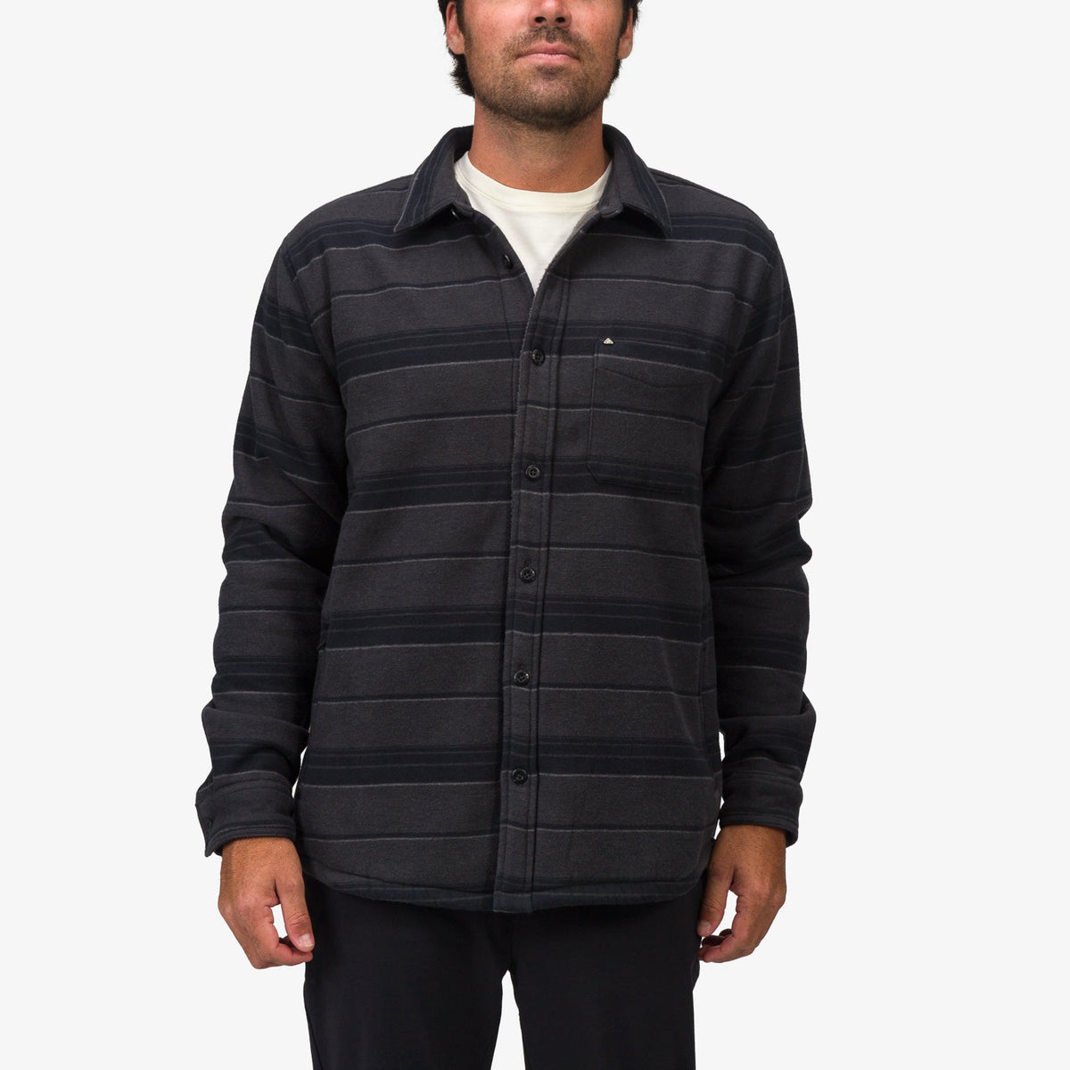 Front view of man wearing Bartlett Woven Jacket with button closure, chest pocket, and striped black fabric, beach-inspired comfort.