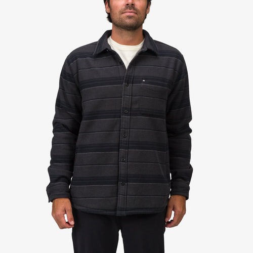 Front view of man wearing Bartlett Woven Jacket with button closure, chest pocket, and striped black fabric, beach-inspired comfort.