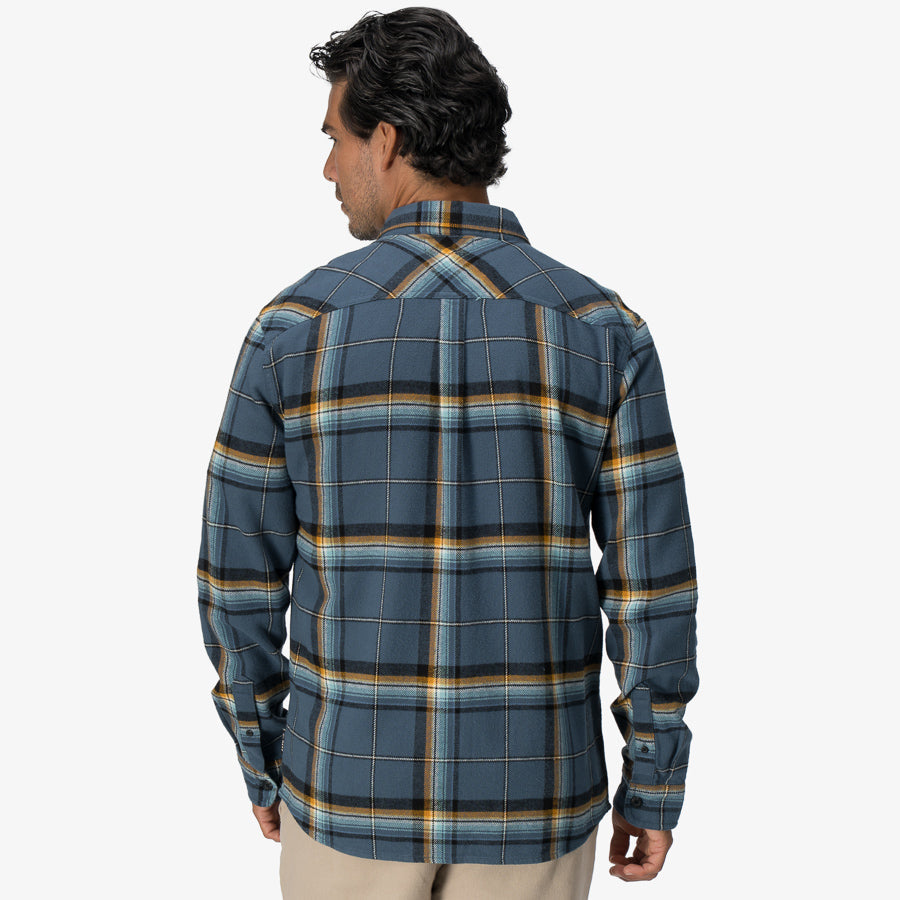 Rear view of a man wearing a blue and yellow plaid Dyson Flannel Shirt, designed for comfort and surf-inspired style.