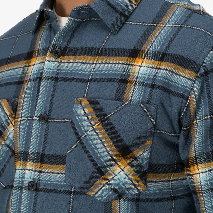 Dyson Flannel Shirt close-up of men's blue plaid fabric with chest pocket, comfort-focused and surf-inspired apparel design.