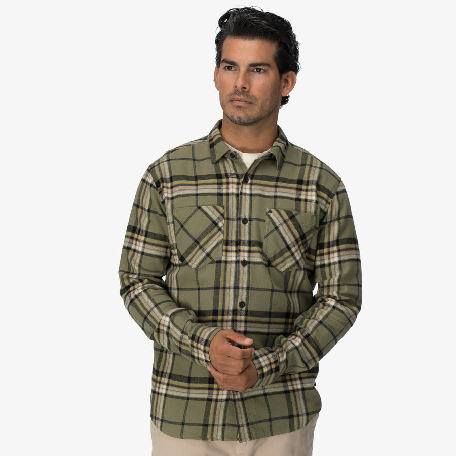 Man facing forward wearing a green and black plaid Dyson Flannel Shirt with front chest pockets and button closure