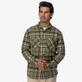 Man facing forward wearing a green and black plaid Dyson Flannel Shirt with front chest pockets and button closure