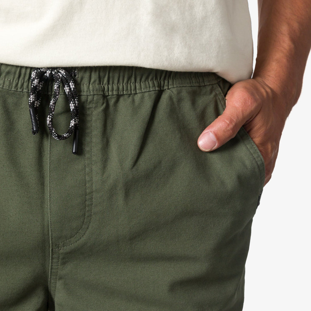 Close-up of men's Matthew Twill Pant in green with hand in pocket, featuring surf-inspired comfort and durable twill fabric.