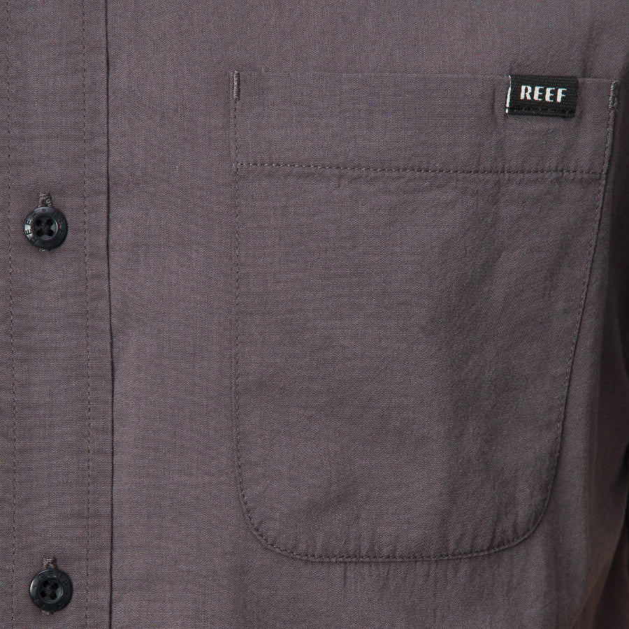 Close-up of the front pocket on the Collins Ss Wvn Shirt in gray with REEF label, designed for comfort and everyday wear.