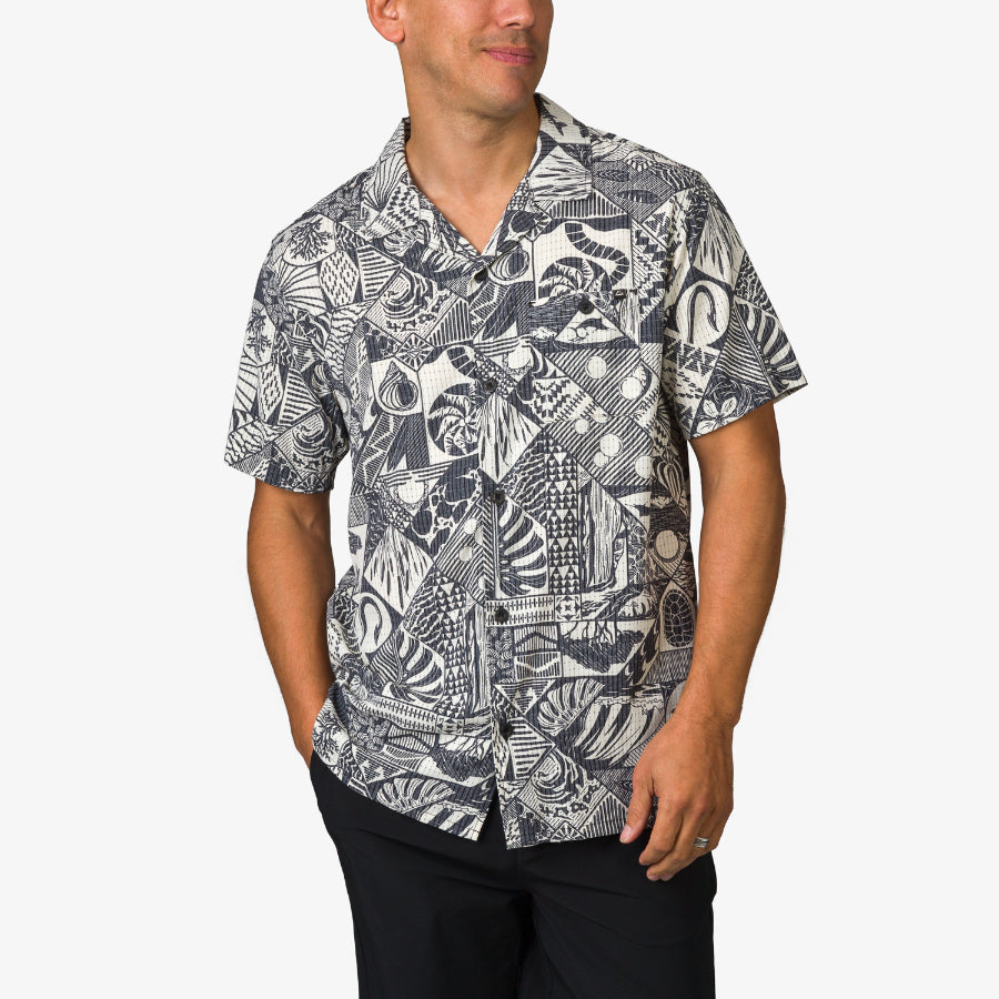 Man wearing a black and white patterned Beckham Camp Shirt with short sleeves, front pocket, and relaxed fit.