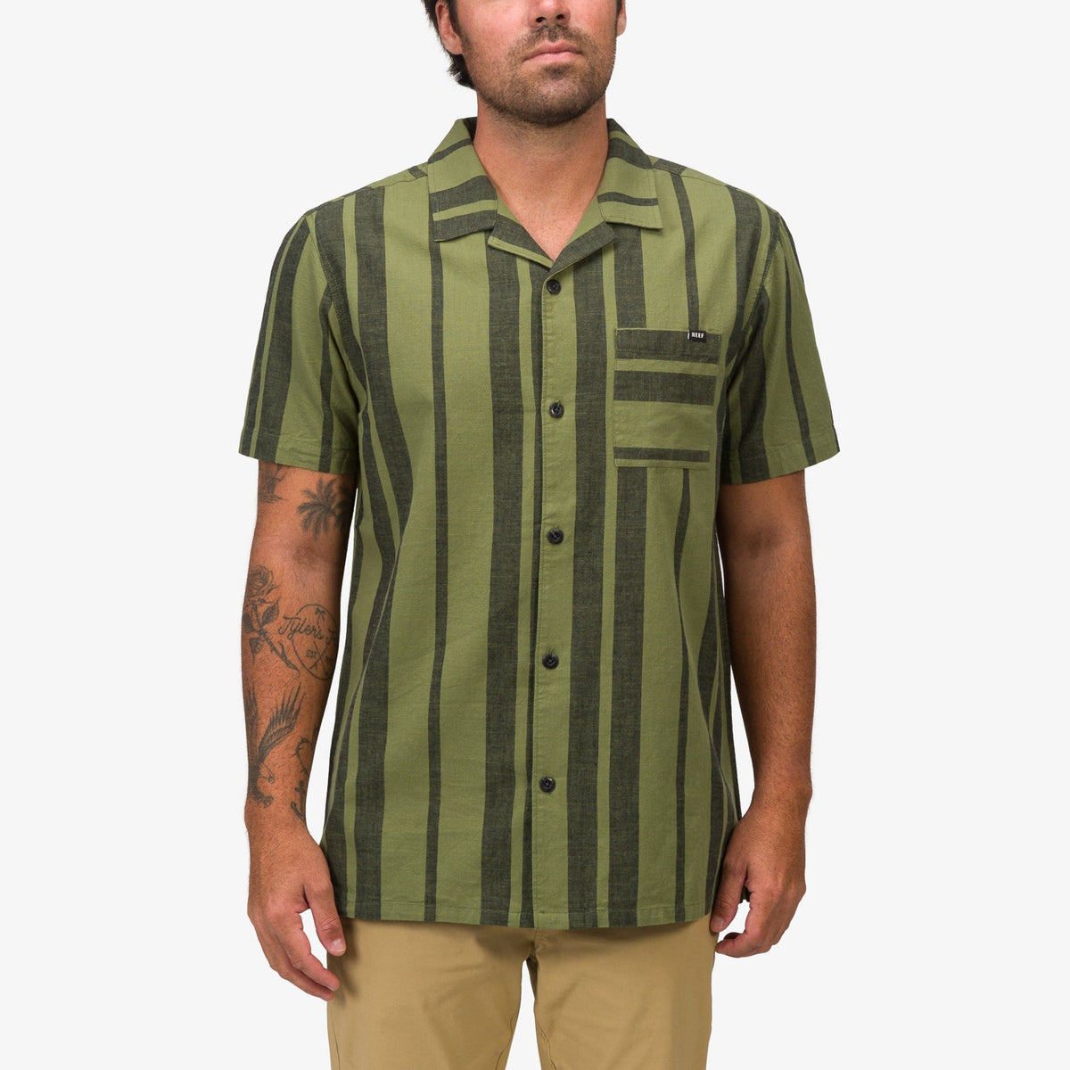 Front view of a man wearing the green striped Angelo Short Sleeve Camp Shirt, beach-inspired casual apparel.