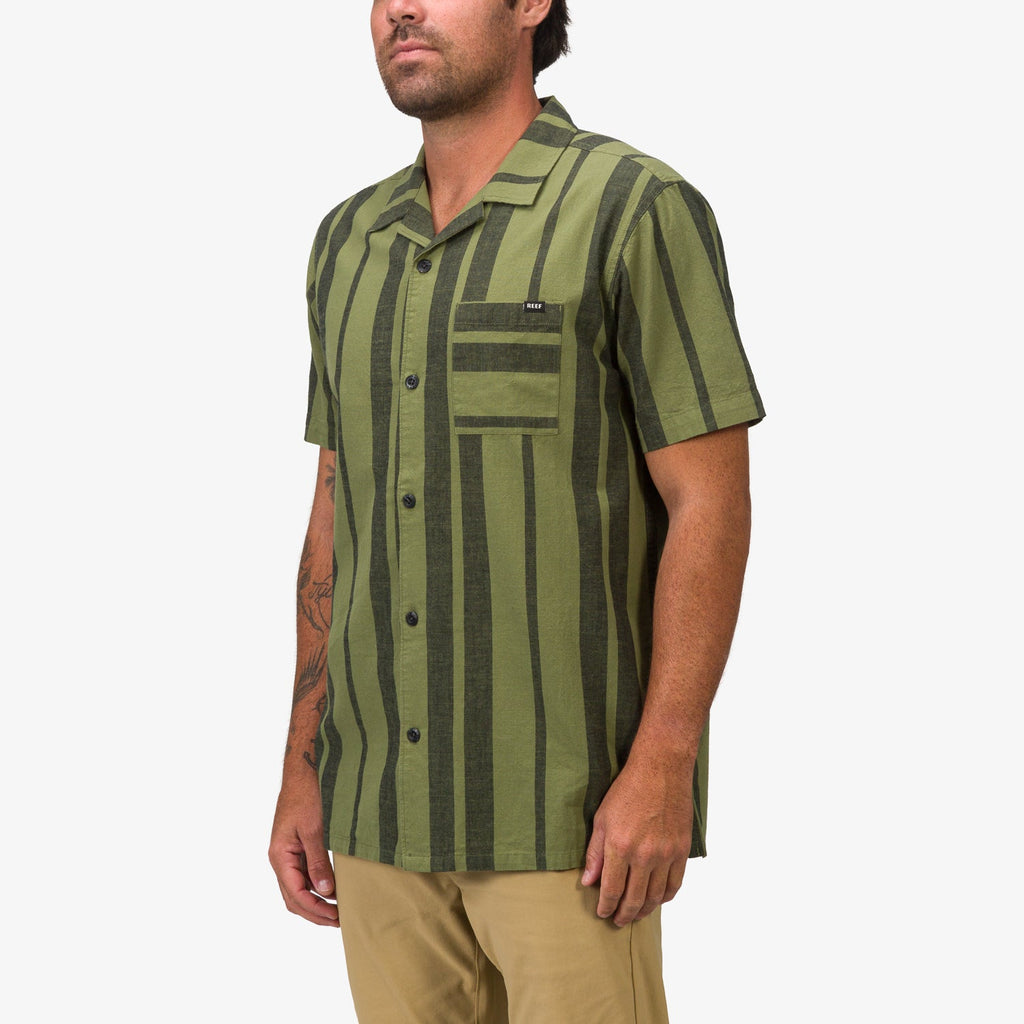 Man wearing olive and dark green striped Angelo Short Sleeve Camp Shirt from front right angle, showing chest pocket and buttons