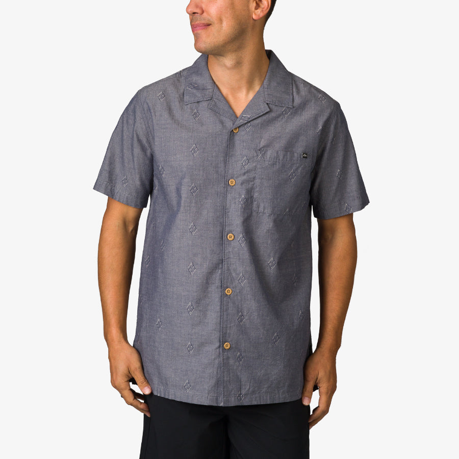 Man wearing a gray Harold Camp Shirt with short sleeves and button front, shown from the front and waist up.
