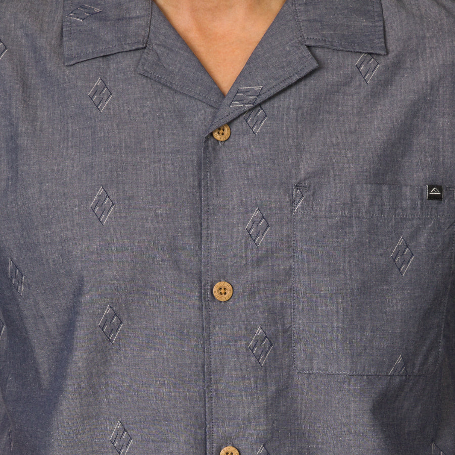 Close-up of the chest area on the Harold Camp Shirt in blue with patterned fabric and wooden buttons.