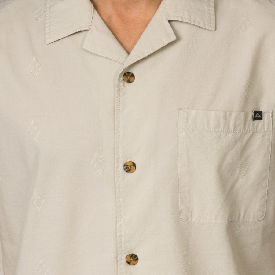 Close-up of the front chest and collar of the beige Harold Camp Shirt with tortoiseshell buttons for men’s beach apparel.
