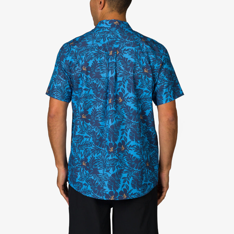 Man wearing Tyson Classic Shirt showing back view with blue tropical leaf pattern, beach-inspired comfort apparel for men.