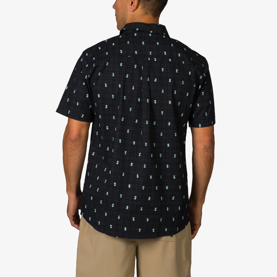 Man wearing Chaplin Classic Shirt in black with blue pattern, back view, styled for beach and active lifestyles.