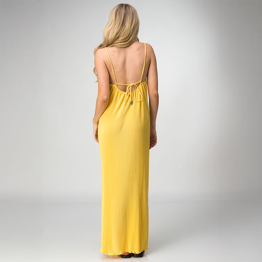 Woman wearing a yellow Plisse Dress facing away, showing back tie detail and lightweight, comfortable fabric flow.
