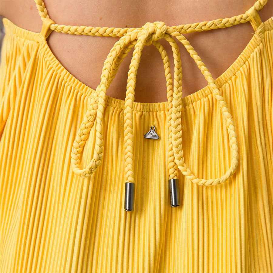 Close-up of back detail on women's Plisse Dress with braided straps and pleated yellow fabric, surf-inspired comfort.