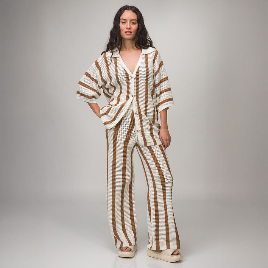 Woman wearing Mika Sweater Pant with vertical brown and white stripes, styled for beach-inspired comfort and casual wear.
