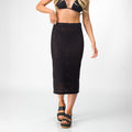 Woman wearing black Mika Sweater Skirt paired with front-facing black platform sandals for beach comfort and style.