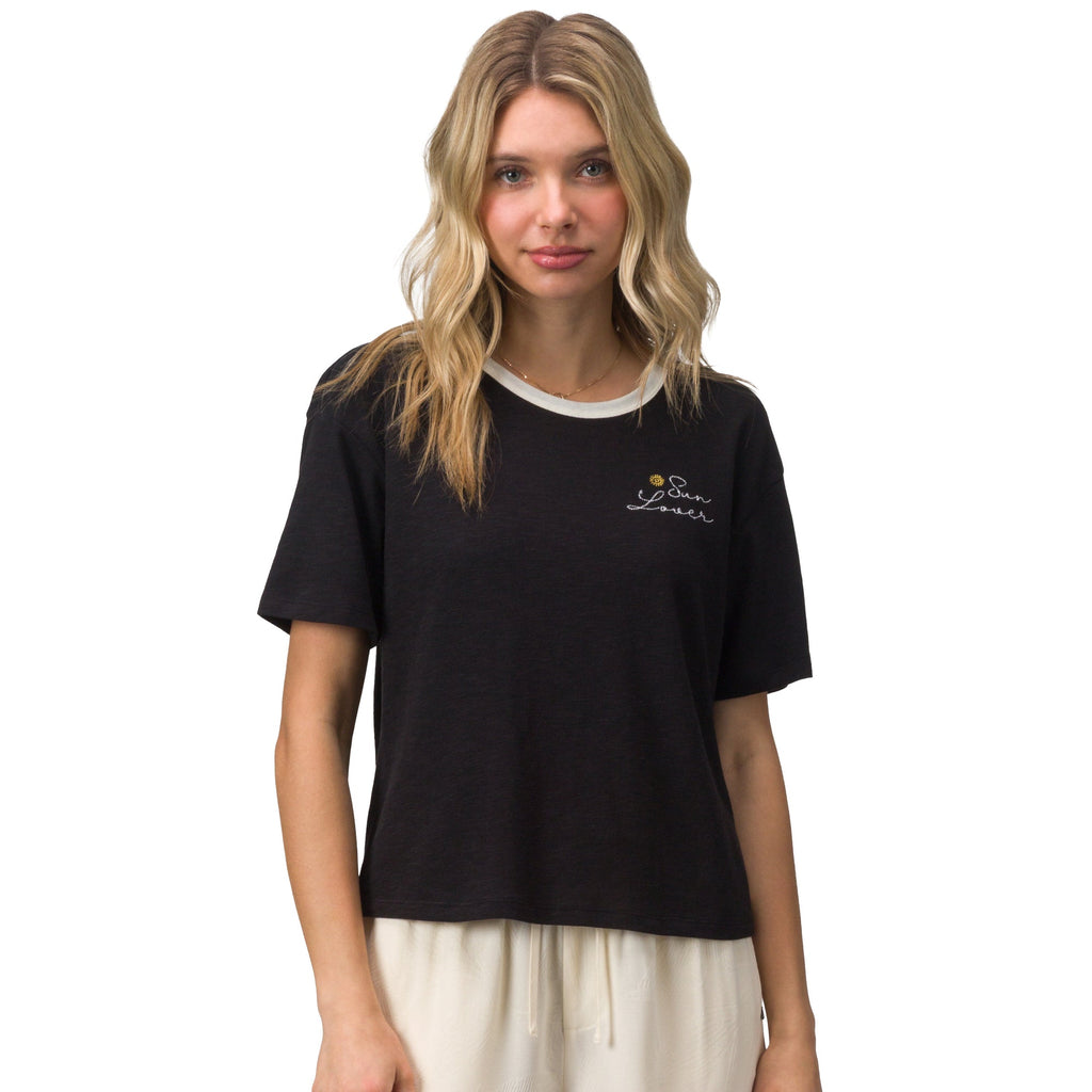 Woman wearing a black Sun Lover Ringer Tee with white collar and small chest logo, front view, beach-inspired comfort apparel.