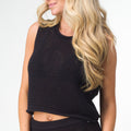 Woman wearing black Mika Sweater Tank showing front upper torso and knit texture, surf-inspired comfort apparel.
