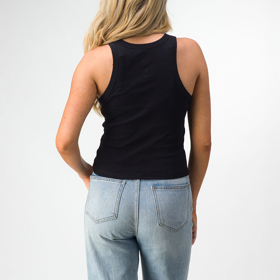Woman wearing a black Day Dream Rib Tank, back view, paired with light blue jeans, casual beach-inspired apparel for women.