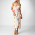 Woman wearing Belladona Dress with floral print paired with tan platform sandals facing forward, showcasing beach-inspired comfort.