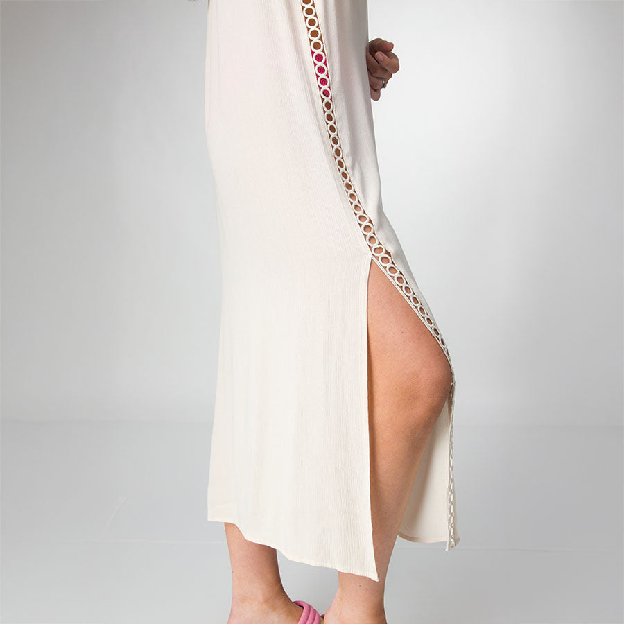 Side view of Irina Shirt Dress in light birch color with open side slit and circular trim detail on adult woman