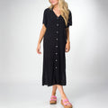 Woman wearing a black Irina Shirt Dress with short sleeves and buttons down front, paired with pink platform sandals facing forward.