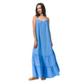 Woman wearing a blue Lainey Maxi Dress with thin straps paired with tan sandals facing left in a full-length shot