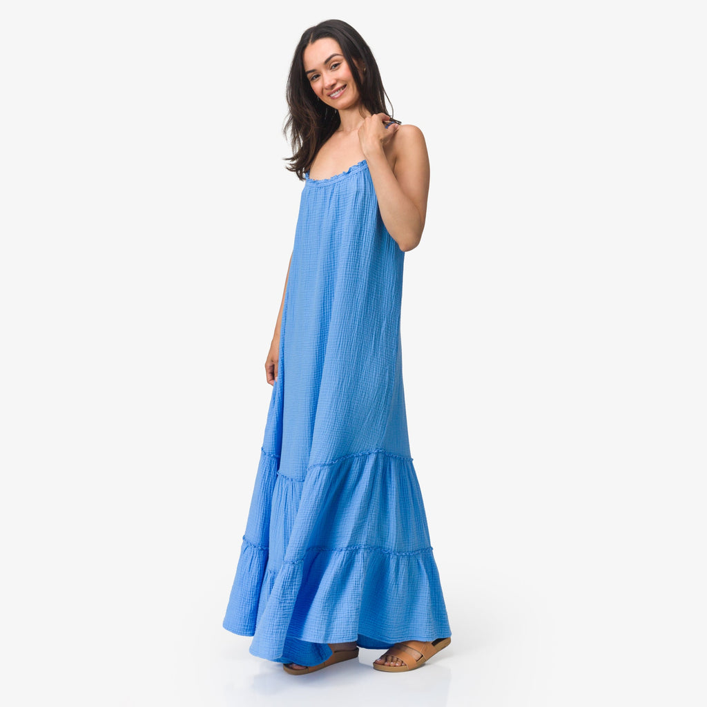 Woman wearing blue Lainey Maxi Dress standing facing forward with relaxed smile, showcasing lightweight beach apparel.