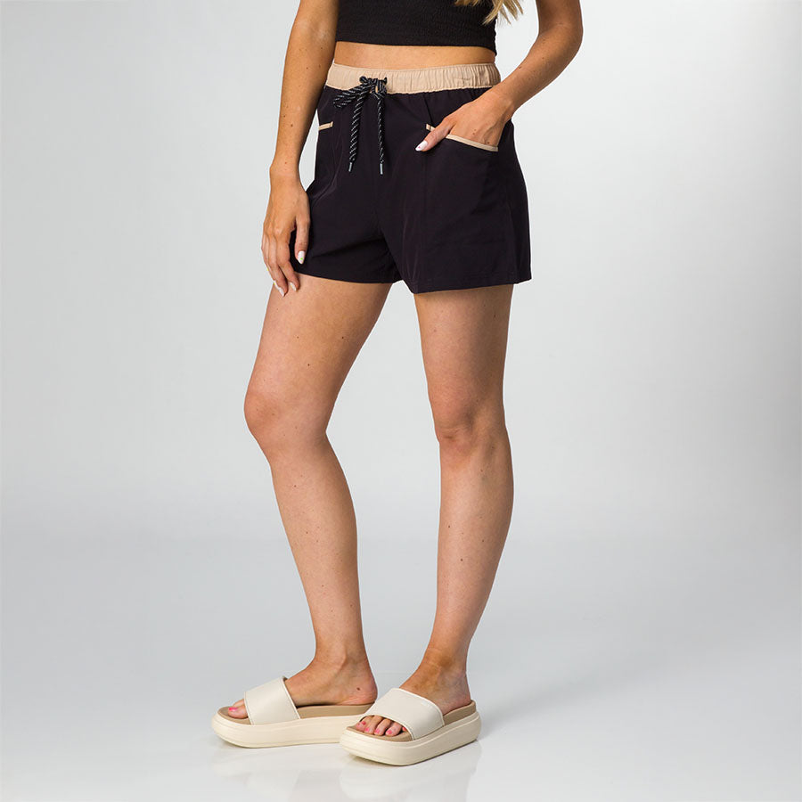 Woman wearing Robyn Short in black with beige waistband, facing forward, paired with beige platform sandals, beach-inspired comfort.