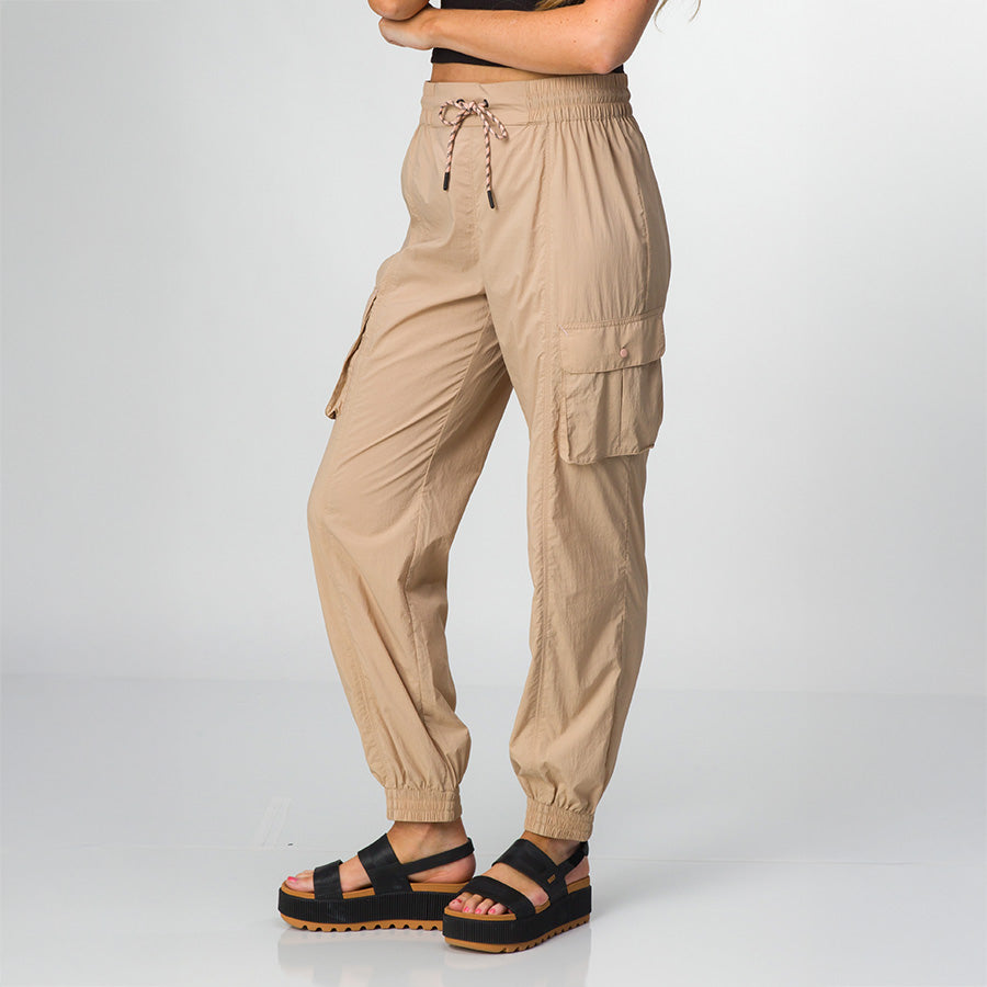 Women wearing tan Cargo Jogger Pant facing right, paired with black platform sandals with ridged sole, side view.
