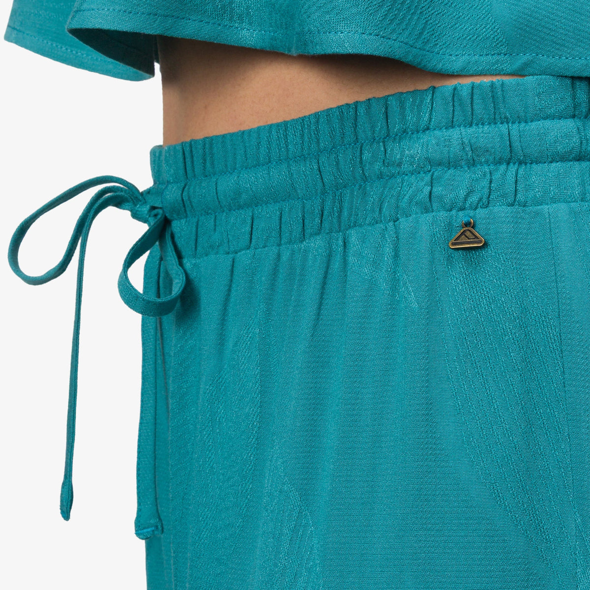 Close-up of the waistband and drawstring of the teal Ollie Pant for women, surf-inspired comfort and style.