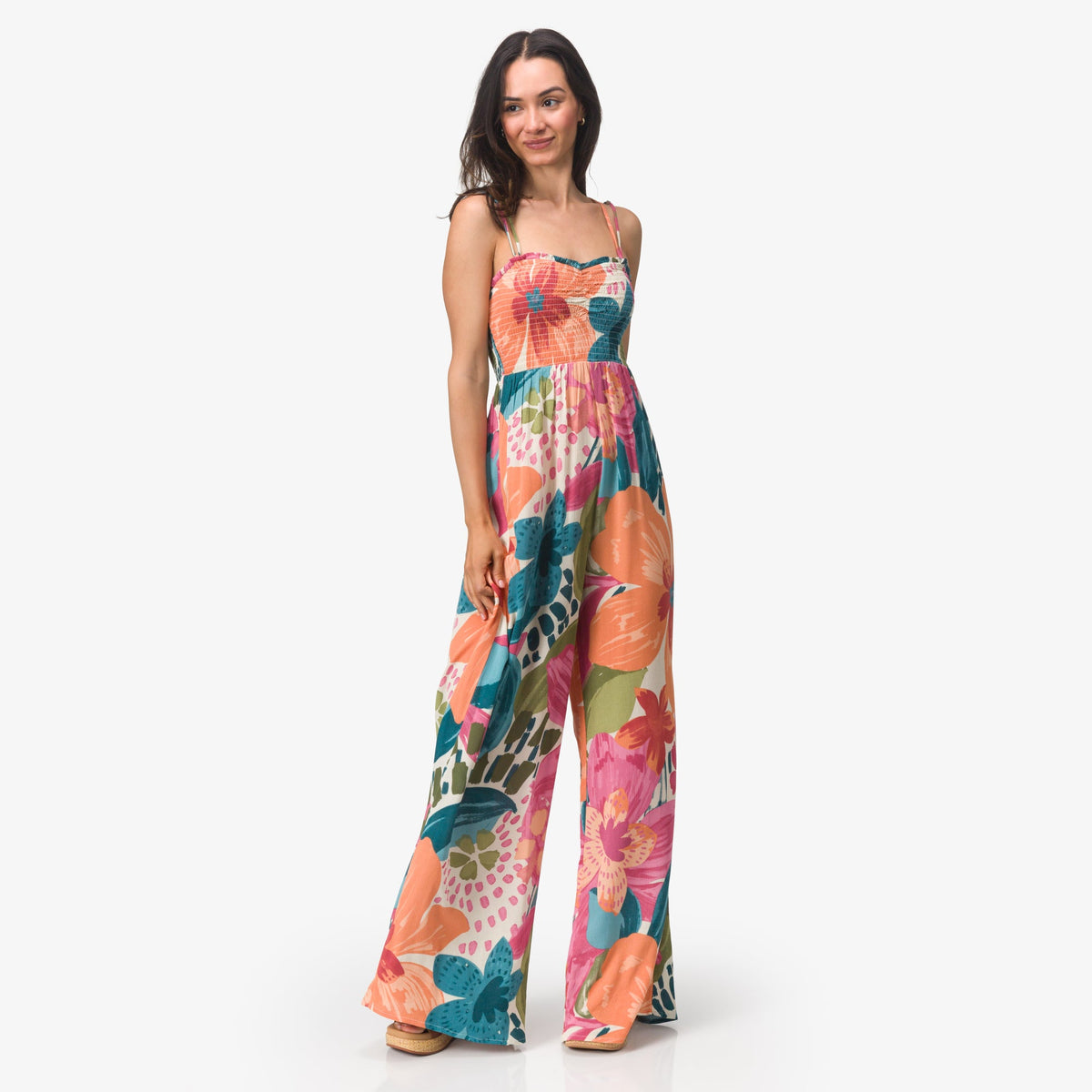 Woman wearing colorful floral Eve Wide Leg Romper standing with relaxed posture, full body view for beach lifestyle apparel.