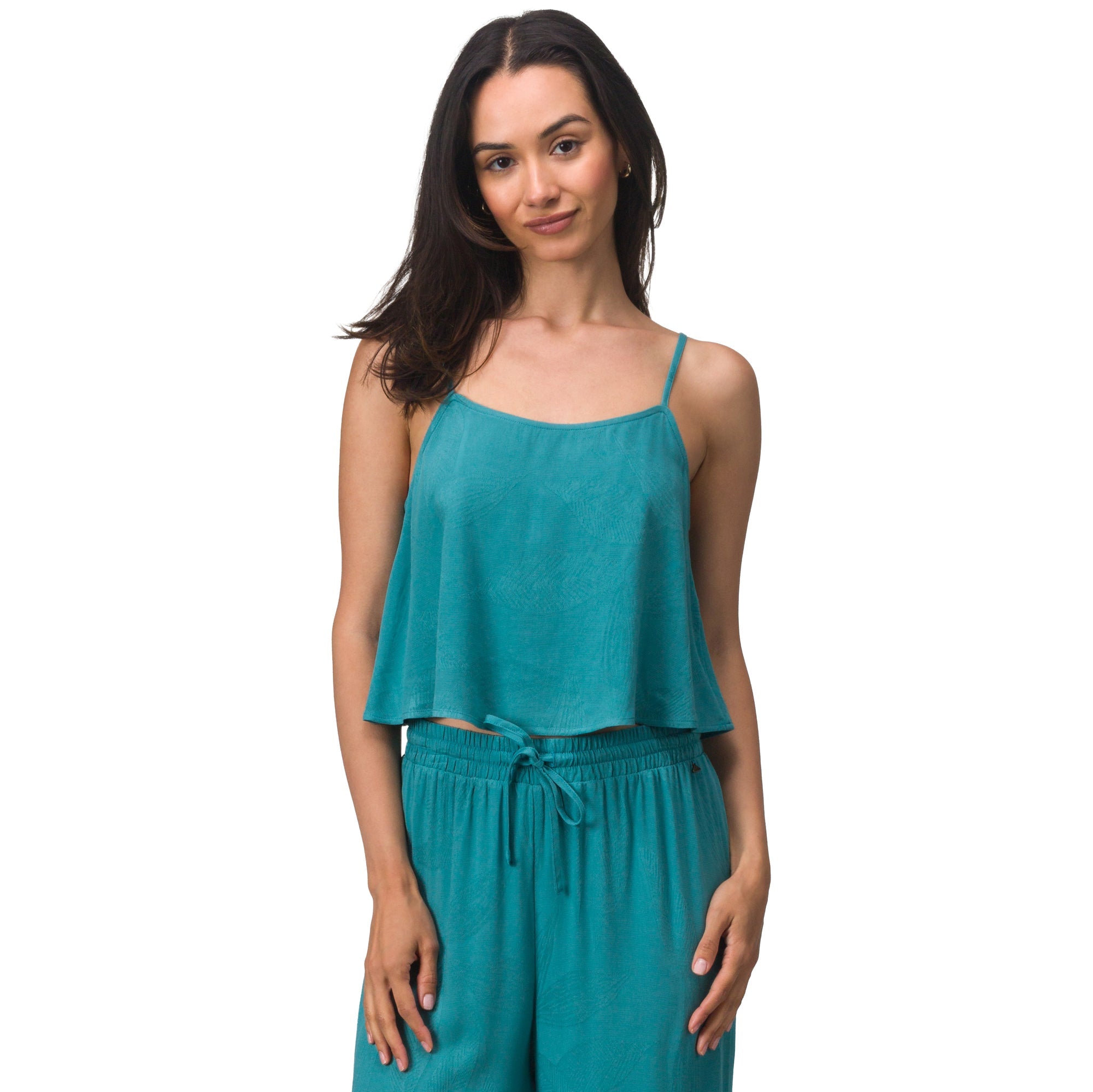 Woman wearing a teal Ollie Tank with thin straps, designed for comfort and a beach-inspired active lifestyle.