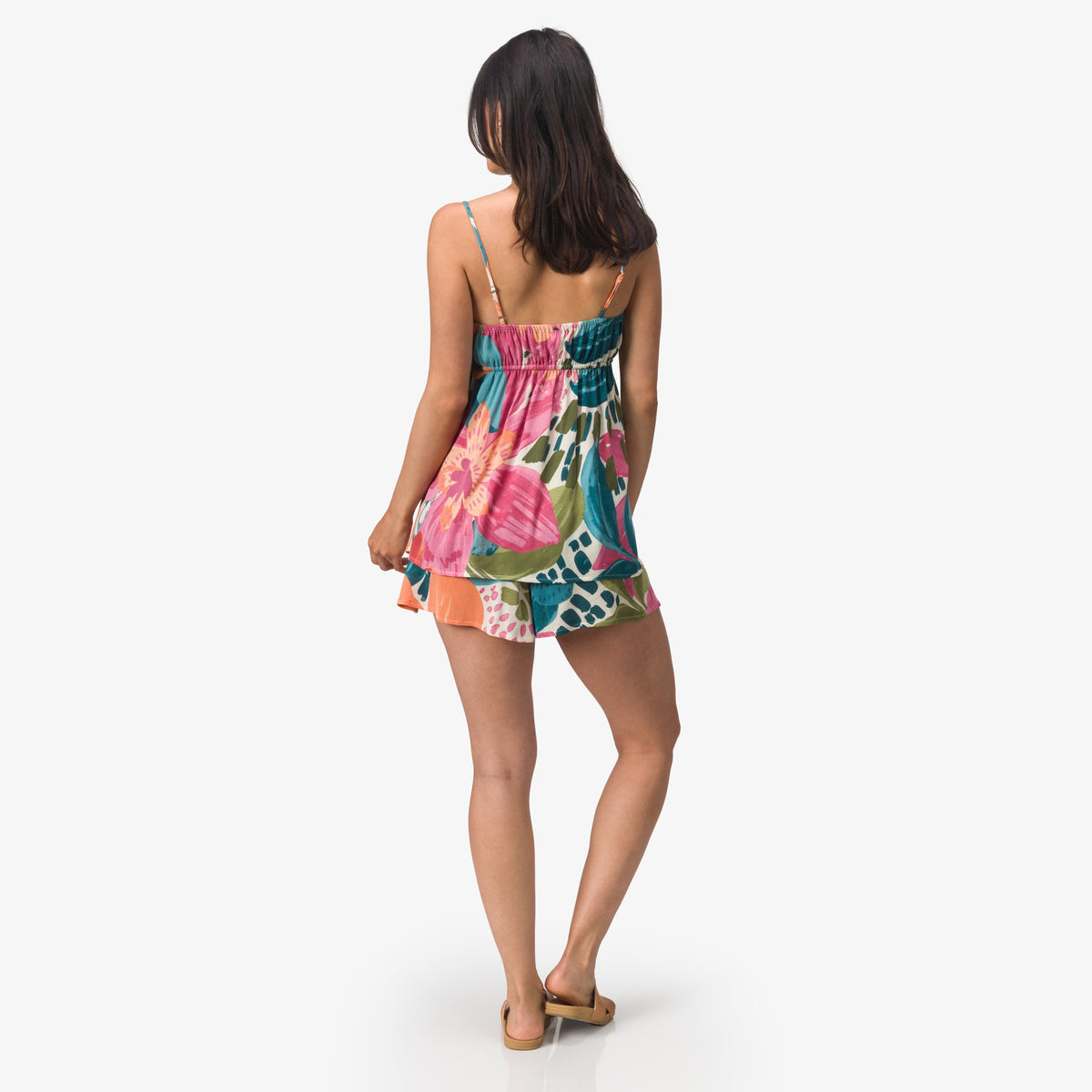 Woman wearing colorful Eve Flutter Short facing away, showcasing lightweight, beach-inspired comfort apparel.