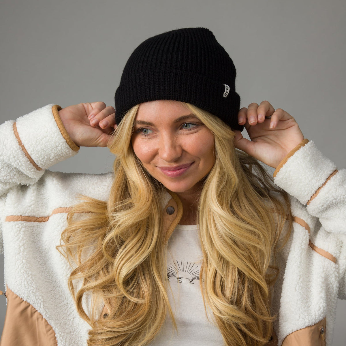 Woman wearing black Alyx Beanie, front view, highlighting comfort and beach-inspired style in cozy apparel.
