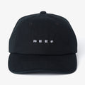 Front view of black Schotts Twill Hat with white REEF logo, featuring lightweight, durable, and comfortable beach-inspired design.
