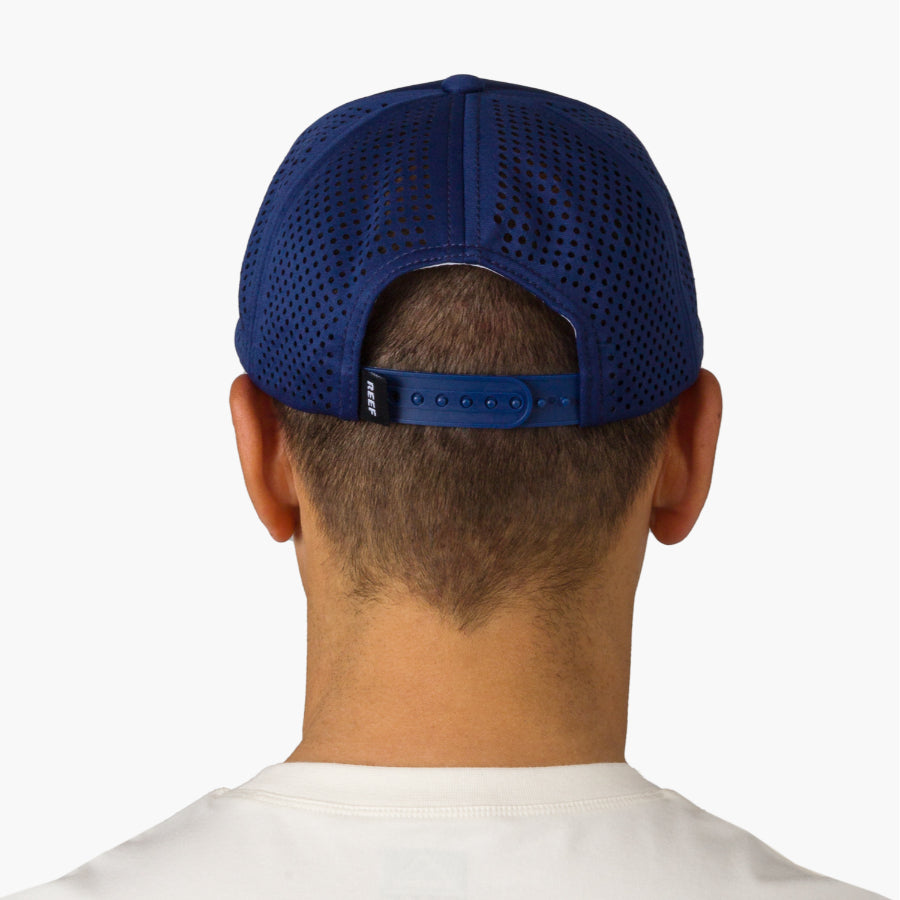 Back view of man wearing a blue Blackball Hat with breathable mesh and adjustable strap, surf-inspired comfort design